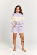 Woman wearing a colorful hoodie and shorts set on a white background