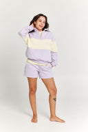 Person wearing a light purple color-blocked outfit on a white background