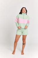 Person wearing a light green and pink outfit on a white background