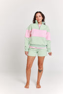 Woman wearing a light green and pink outfit on a white background