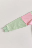 Light green and pink color-blocked quarter zip jumper on a white background